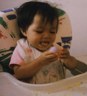 baby making a mess with an egg