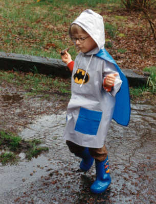 boy playing in rain puddle