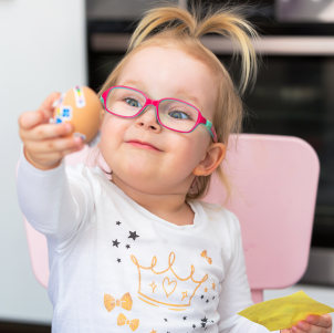 young child with glasses attaches stickers